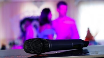 Close up on a microphone, on stage of a business meeting or event with flare light effect and copyspace.