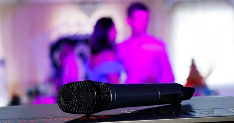Close up on a microphone, on stage of a business meeting or event with flare light effect and copyspace.