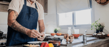 A man cooking in front of a stove.