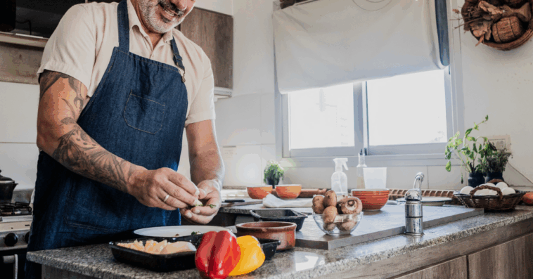 A man cooking in front of a stove.