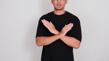 A man crossing his arms in front of his chest.