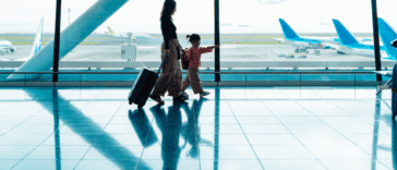 A woman with a child walking through the airport.