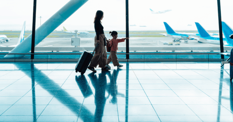 A woman with a child walking through the airport.