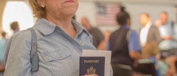 Mature woman holds a passport and boarding pass at airport.