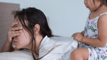 woman in bed ignoring child on her back