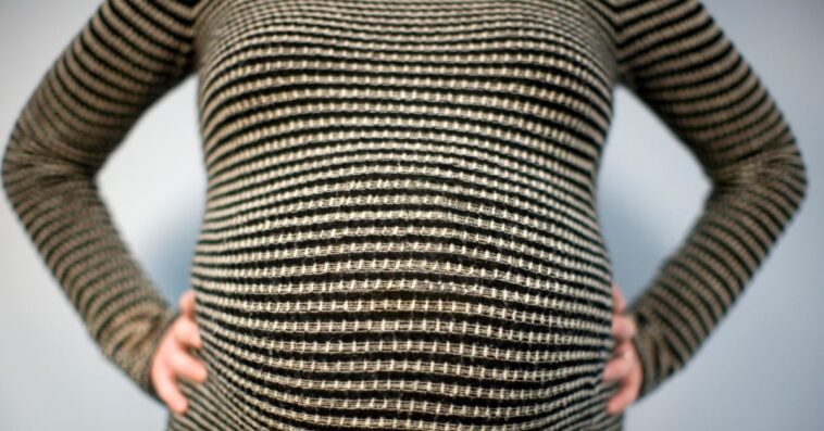 Close- up shot of a pregnant woman's stomach.