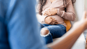 Pregnant woman with her hands on her stomach