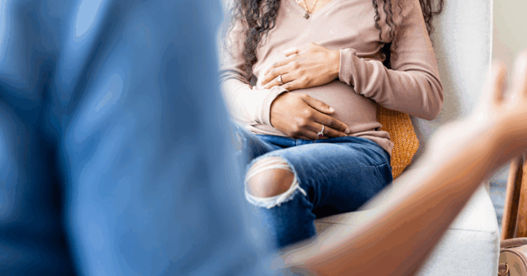 Pregnant woman with her hands on her stomach