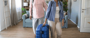 A couple entering a home with luggage