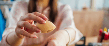 A Woman applying makeup on her hand.