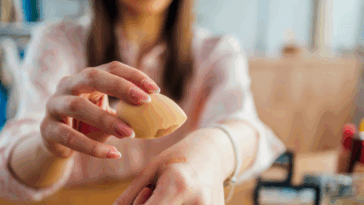 A Woman applying makeup on her hand.