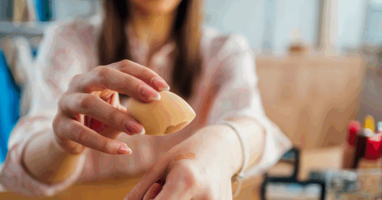 A Woman applying makeup on her hand.