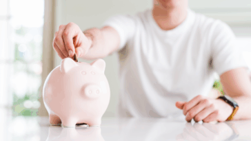 teen putting money in a piggy bank