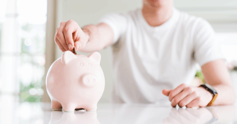 teen putting money in a piggy bank