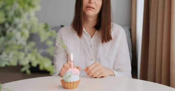 sad woman with birthday cupcake