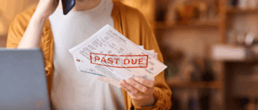 Woman frustrated while looking at past due bills