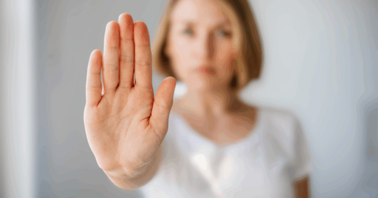 woman with hand up in front of her to indicate "no"