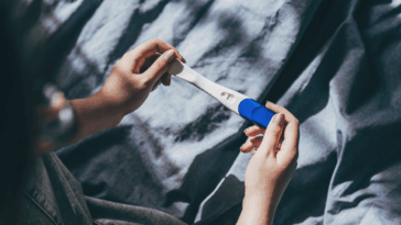 person looking at pregnancy test