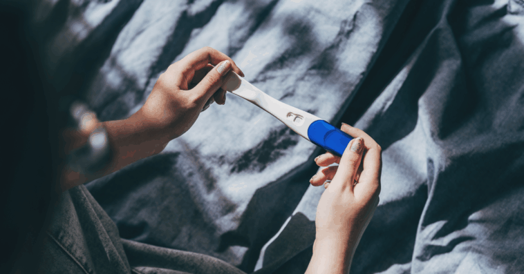 person looking at pregnancy test