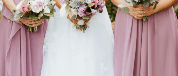 A bride surrounded by two bridesmaids.