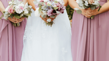 A bride surrounded by two bridesmaids.