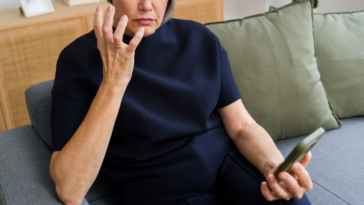 Stunned older woman looking at her phone