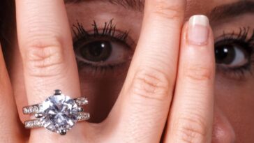 Extreme close-up shot of a beautiful young woman's eye as she shows off her diamond engagement ring - stock photo.