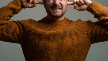 Guy covering his ears