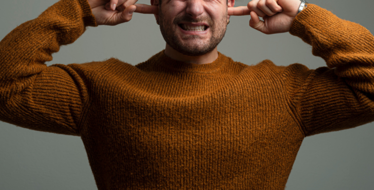 Guy covering his ears