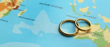 A pair of wedding rings laying on a map.