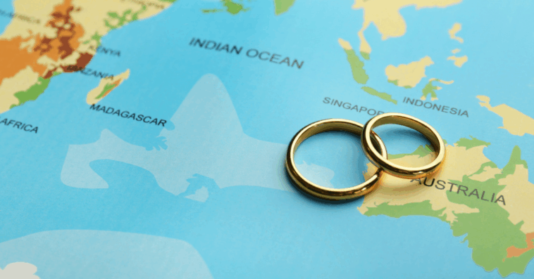 A pair of wedding rings laying on a map.