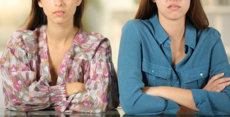 Angry friends ignoring each other at home.