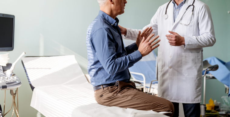 A. man sitting on an examination table talking to a doctor.