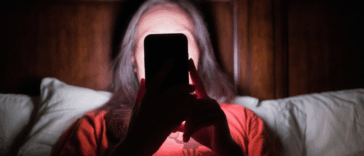 Woman looking at her phone in the dark