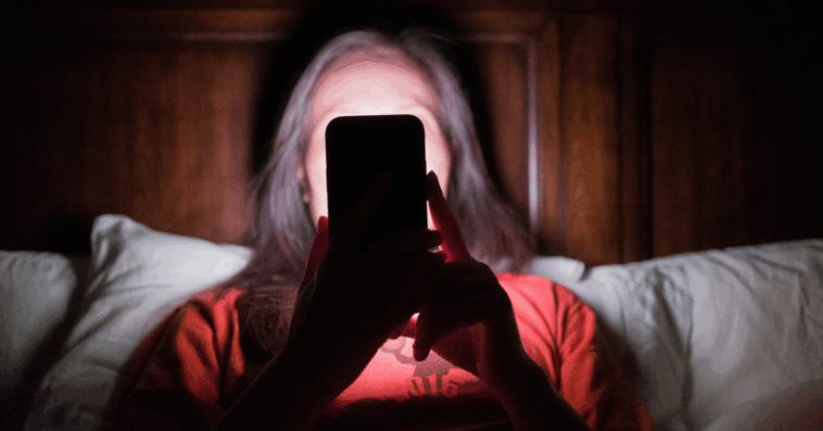 Woman looking at her phone in the dark