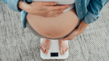 Pregnant woman standing on scale