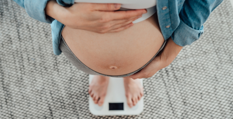 Pregnant woman standing on scale