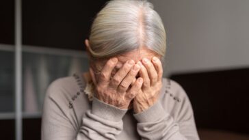 Depressed Senior Woman Covers Her Face With Both Hands.