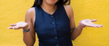 Young woman shrugging with her hands to the sides.