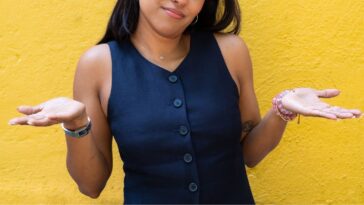 Young woman shrugging with her hands to the sides.
