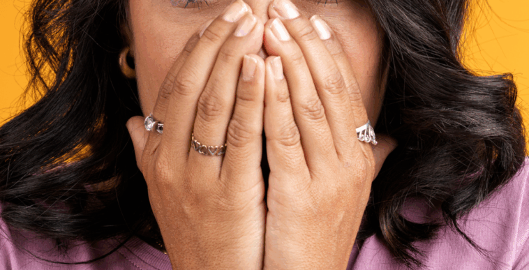 A woman covering her mouth.