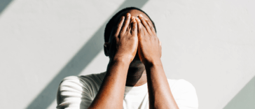 A man covering his face with his hands.