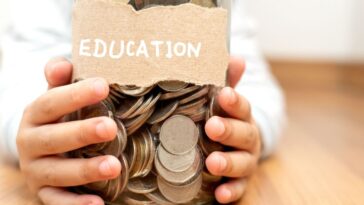 A child's hands holds a jar of coins that is labeled... "Education."