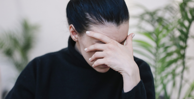 Frustrated woman with her hand covering her face