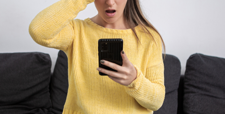 Woman shocked while looking at her phone