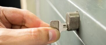 Close-up of a man's hand opening the cabinet with a key.
