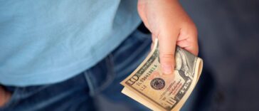 Unidentified young boy holds ten dollars.