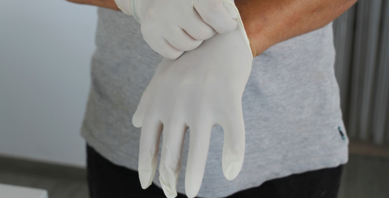 A man putting on latex Gloves