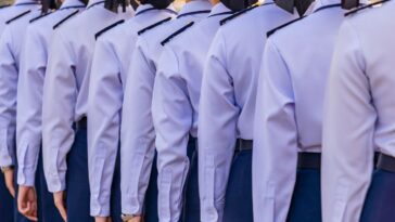 Female soldiers in light blue uniforms stand in line.