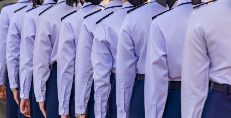 Female soldiers in light blue uniforms stand in line.